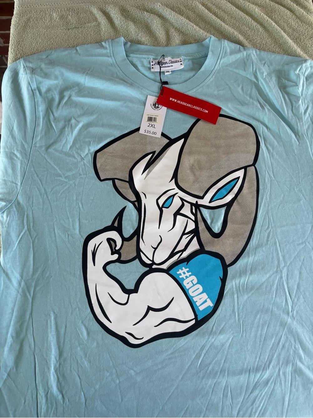 Men's Light Blue Short Sleeve Graphic Tee with GOAT Ram Emblem